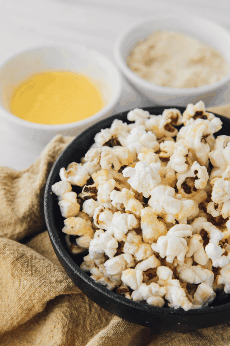 Golden, fluffy popcorn popping in a cast iron skillet, ready to serve.