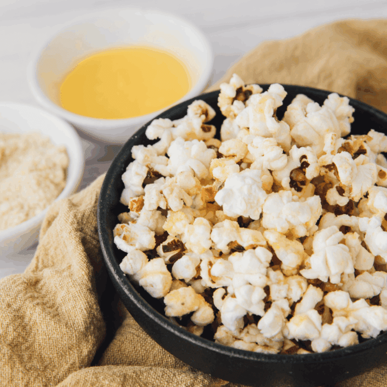 Freshly popped, golden popcorn in a cast iron skillet ready to serve.