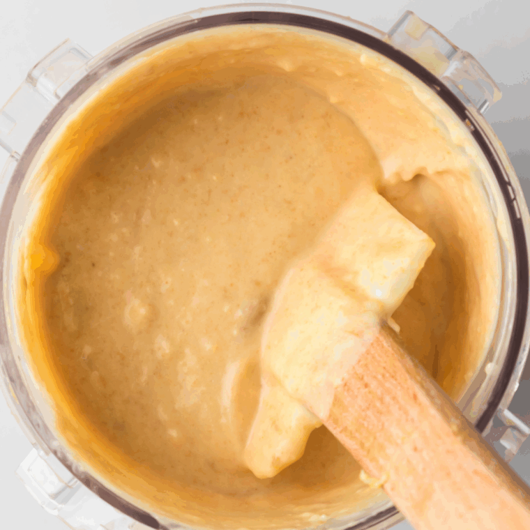 Pouring the chocolate peanut butter ice cream mixture into a Ninja Creami pint container and sealing it with a lid before freezing for 24 hours.