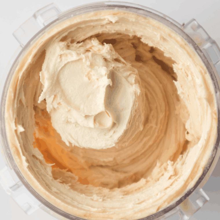 Placing the frozen Ninja Creami pint into the machine, running the Ice Cream function, then adding milk and re-spinning for a smooth, creamy texture.