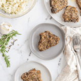 Grilled Moroccan lamb chops on a plate, garnished with fresh herbs and lemon wedges.