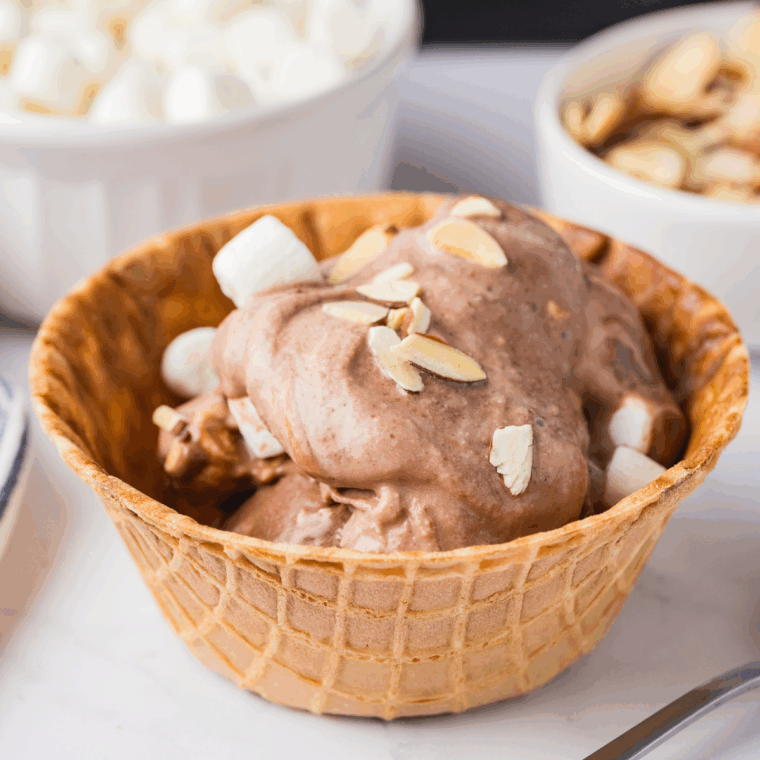 Scooping creamy Rocky Road ice cream into bowls, ready to enjoy immediately.
