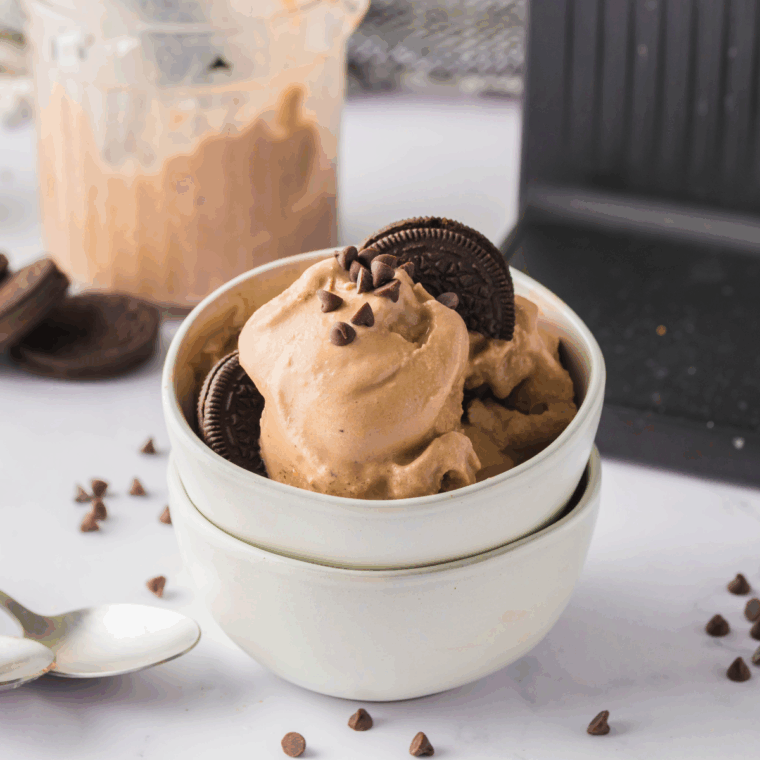 Bowl of homemade Oreo Monkey Business ice cream topped with chocolate swirls and cookie pieces.
