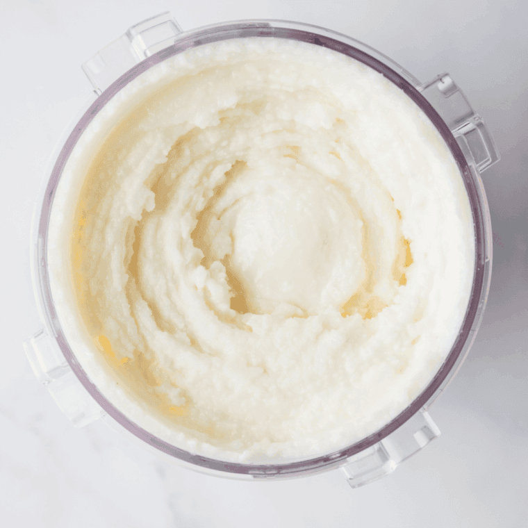 Vanilla ice cream and milk in a pint container being mixed with neon green food coloring.