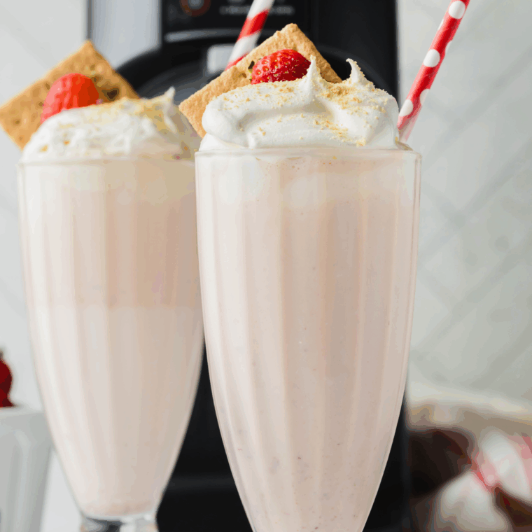 Easy Ninja Slushi Eggnog Milkshake on kitchen counter, with whipped cream and fresh fruits.
