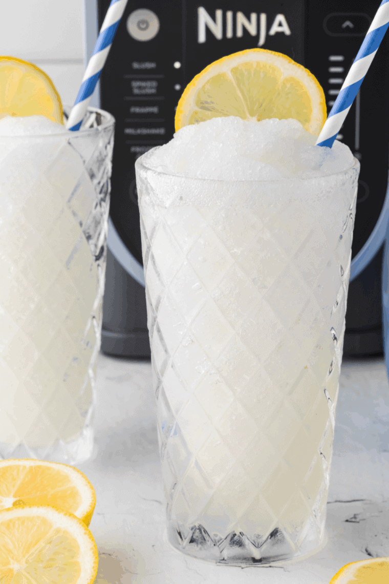 Frosted lemonade slush served in a glass with lemon slice garnish.