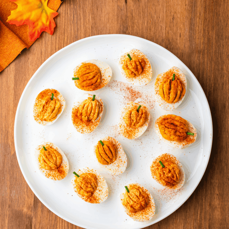 Piping orange yolk filling into egg white halves