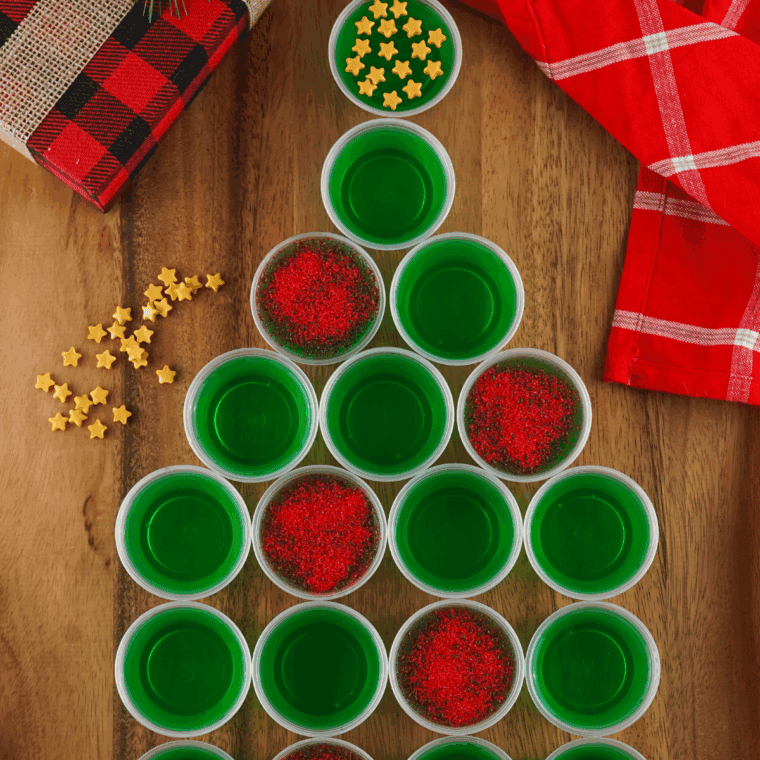 Completed sparkling Christmas tree Jello shots displayed on a holiday table ready to serve.