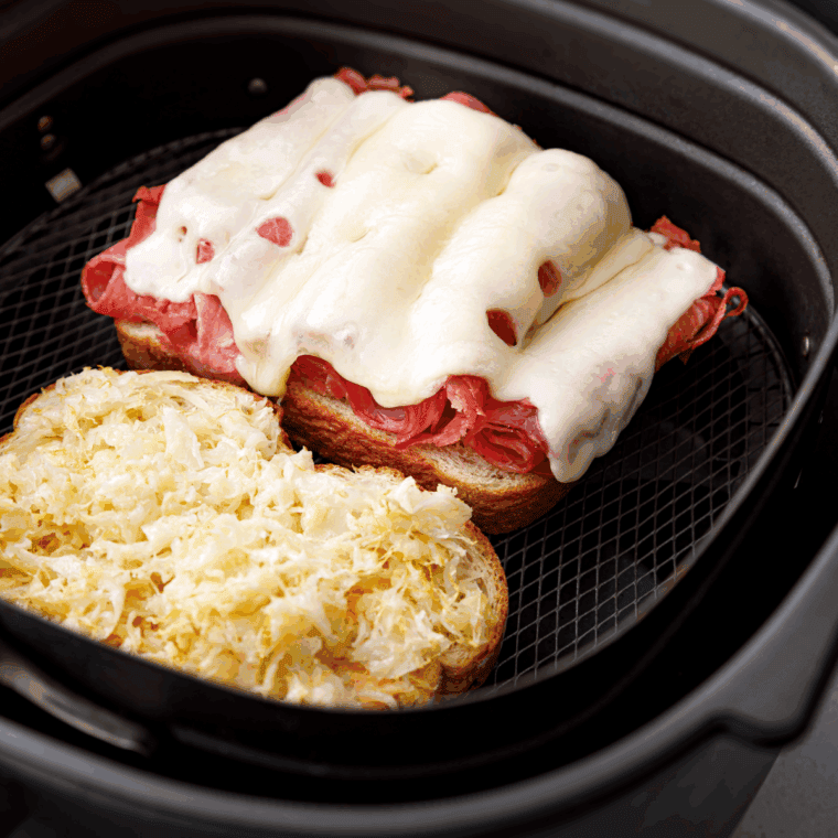 Flipping the Reuben sandwich on a hot griddle until golden and melted.