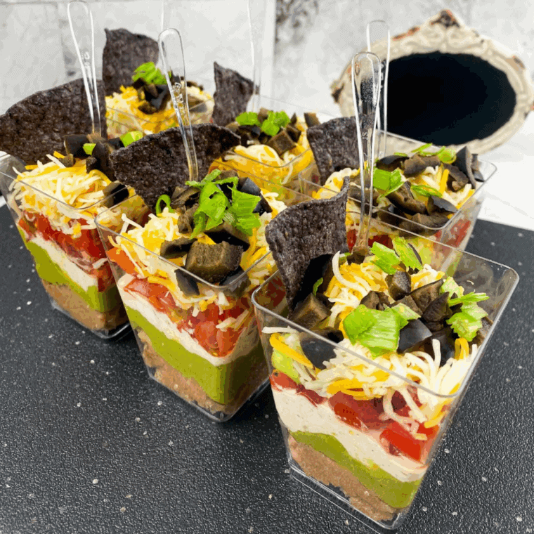 Bunch of Easy 7 Layer Dip Cups on kitchen table.