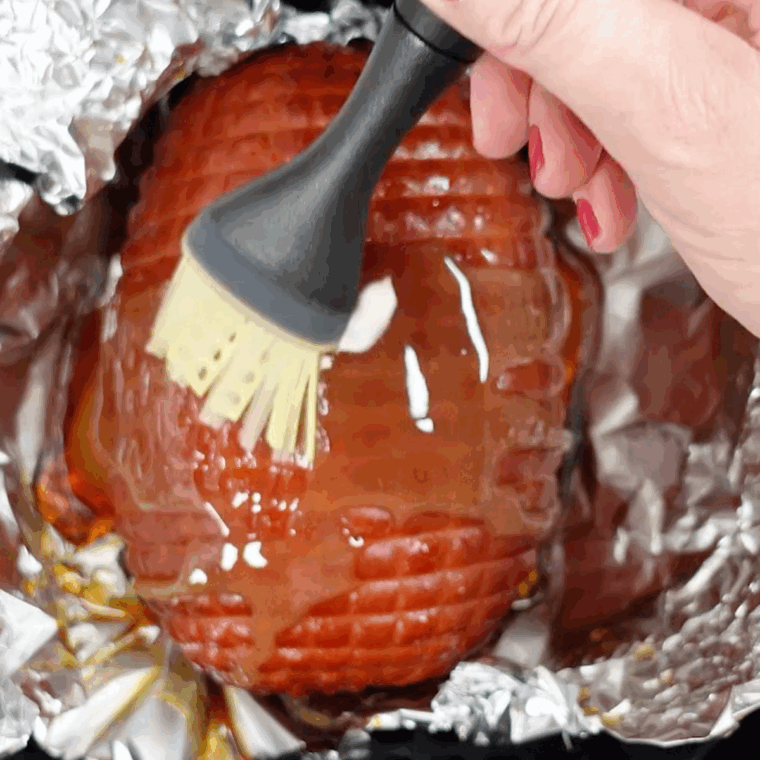 Basting the ham with the sauce.