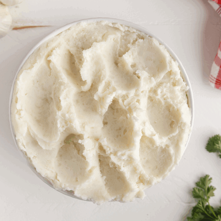Large bowl of fluffy, rich, and creamy Golden Corral Mashed Potatoes topped with a pat of melting butter.