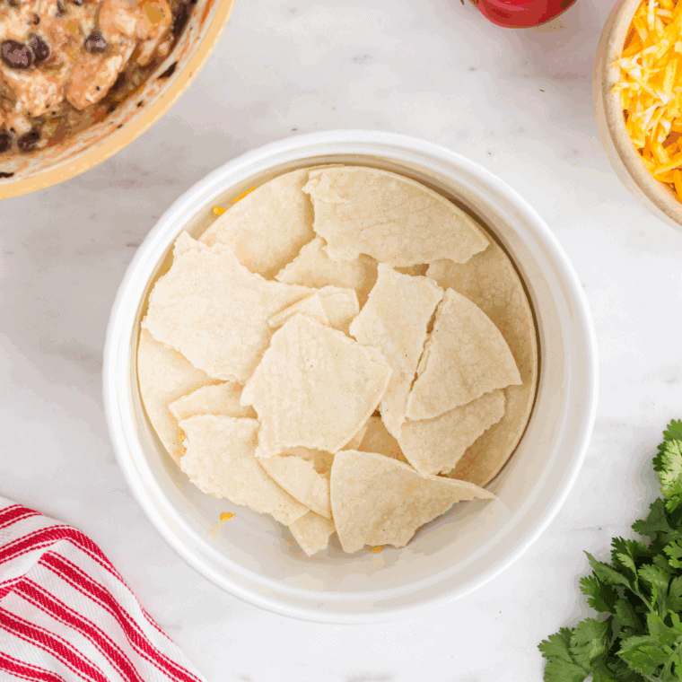 Crushed tortilla chips spread evenly in baking dish.