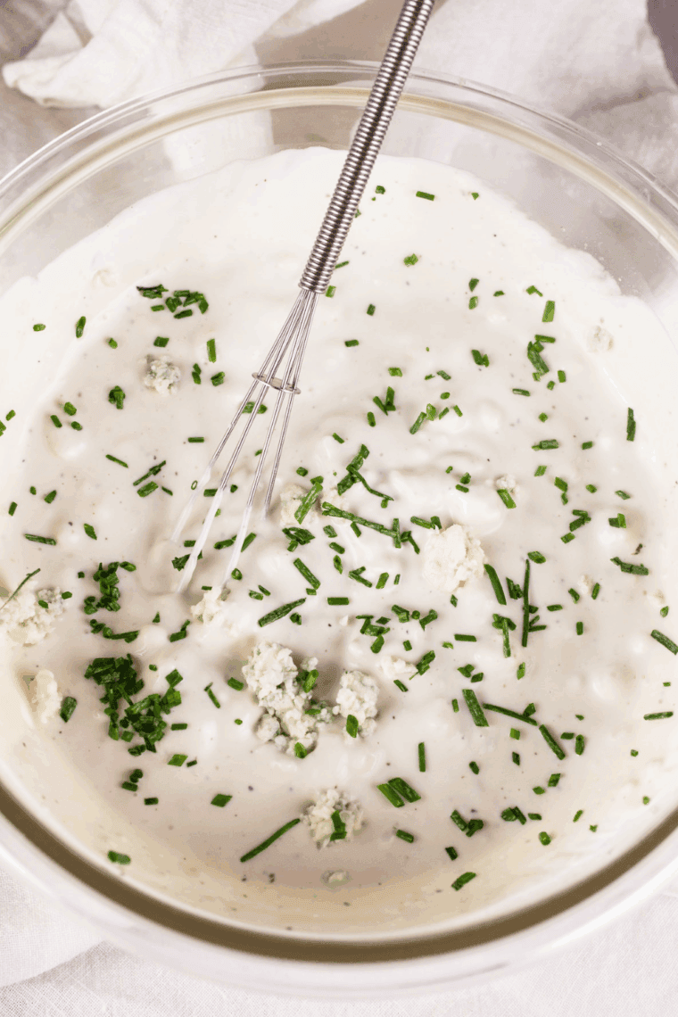 Ruth’s Chris Steak House bleu cheese dressing in a white bowl with blue cheese crumbles