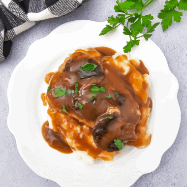 Homemade Texas Roadhouse brown gravy served in a small bowl with a spoon.
