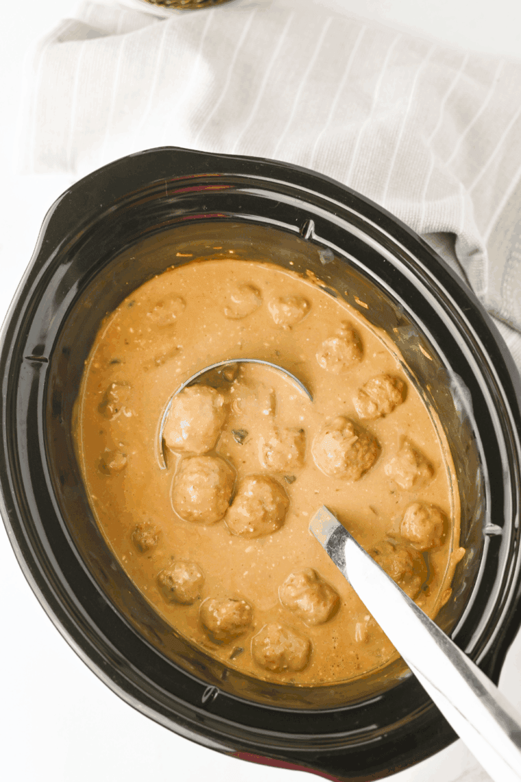 Creamy Swedish meatballs in a crockpot, served in sauce and ready to enjoy.