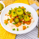 Bowl of Easy Nashville Hot Chicken Dip topped with seasoning and served with chips.
