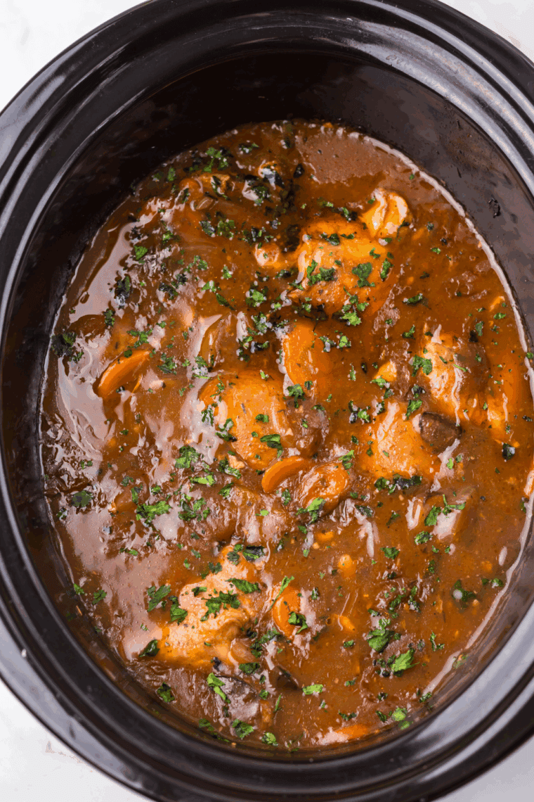 Slow cooker chicken merlot served over mashed potatoes with parsley garnish
