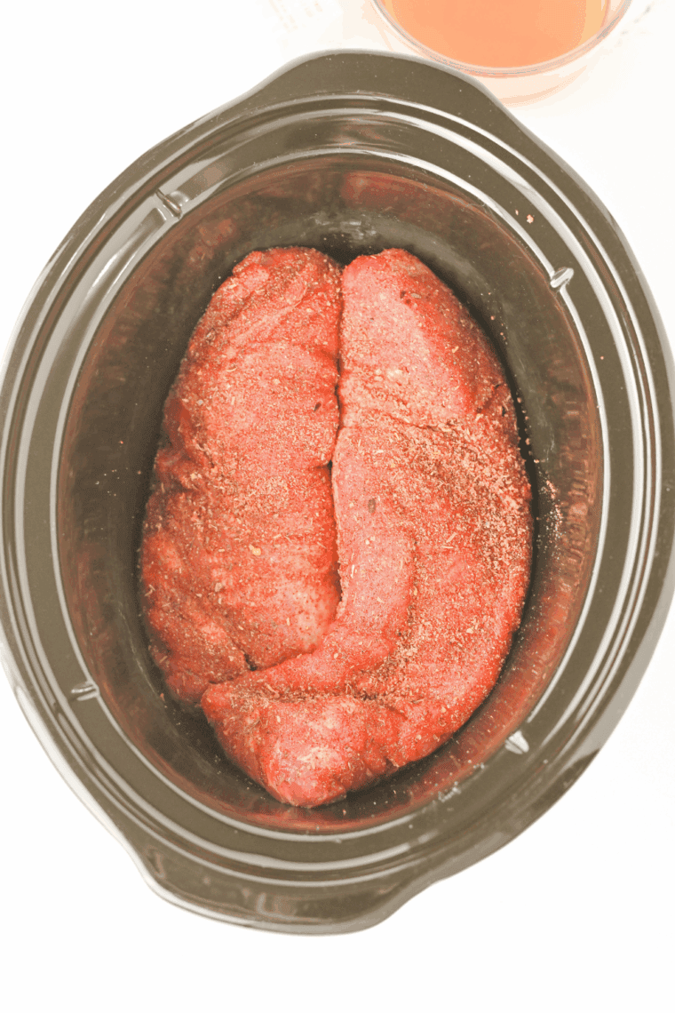 Pork tenderloin searing to a deep golden brown in a cast iron skillet