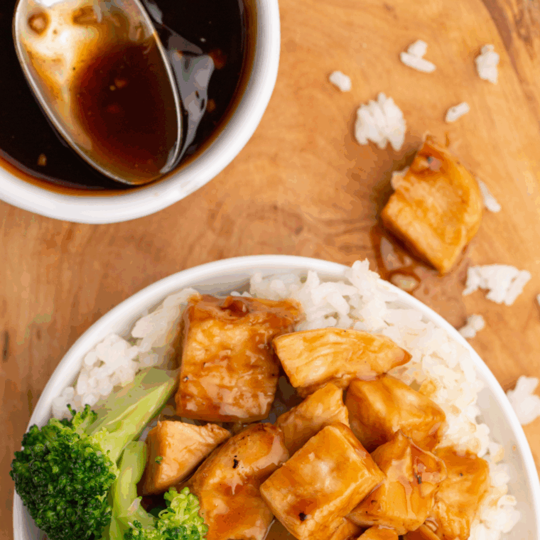 Bowl of Easy Teriyaki Miso Sauce garnished with sesame seeds and scallions, ready to drizzle over chicken.