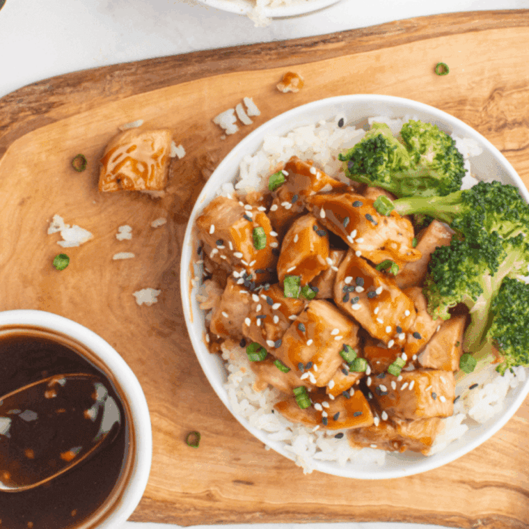 Bowl of Easy Teriyaki Miso Sauce with sesame seeds and scallions, ready to drizzle over grilled chicken.