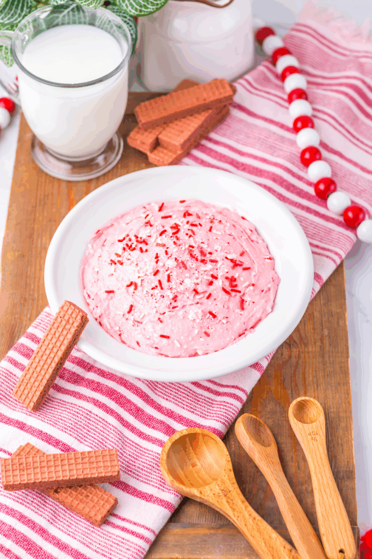Valentine’s Day Fluff dessert served in a bowl with pink coloring, sprinkles, and chocolate wafer cookies