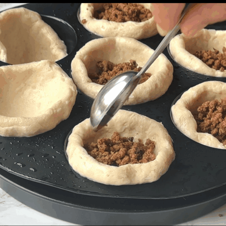 Add the seasoned taco meat the biscuit cup.
