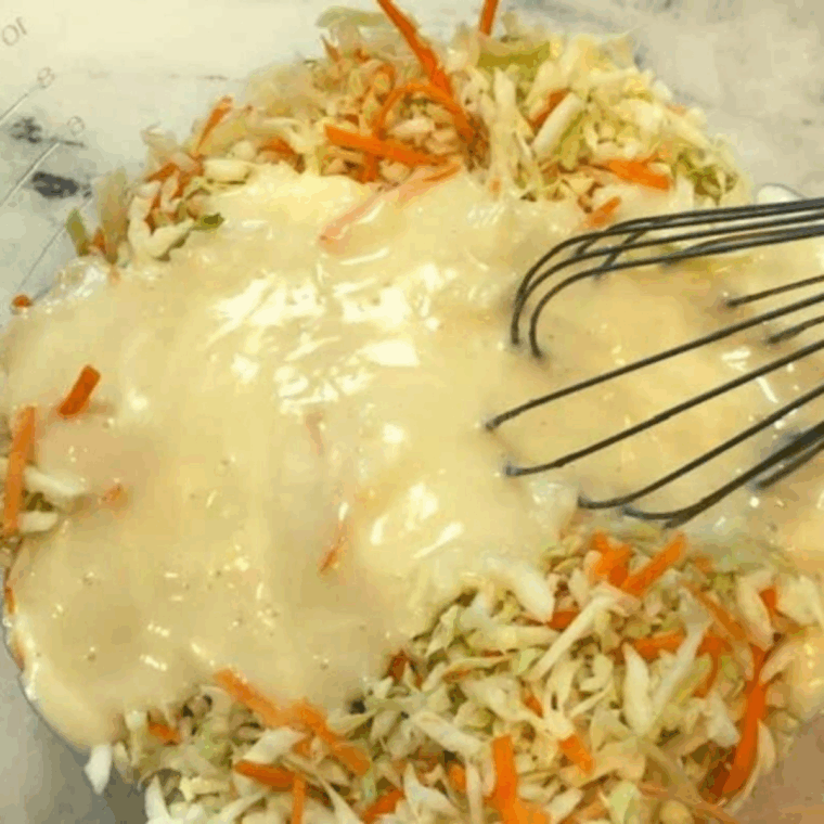 Pouring dressing over cabbage and carrots and tossing to coat evenly.