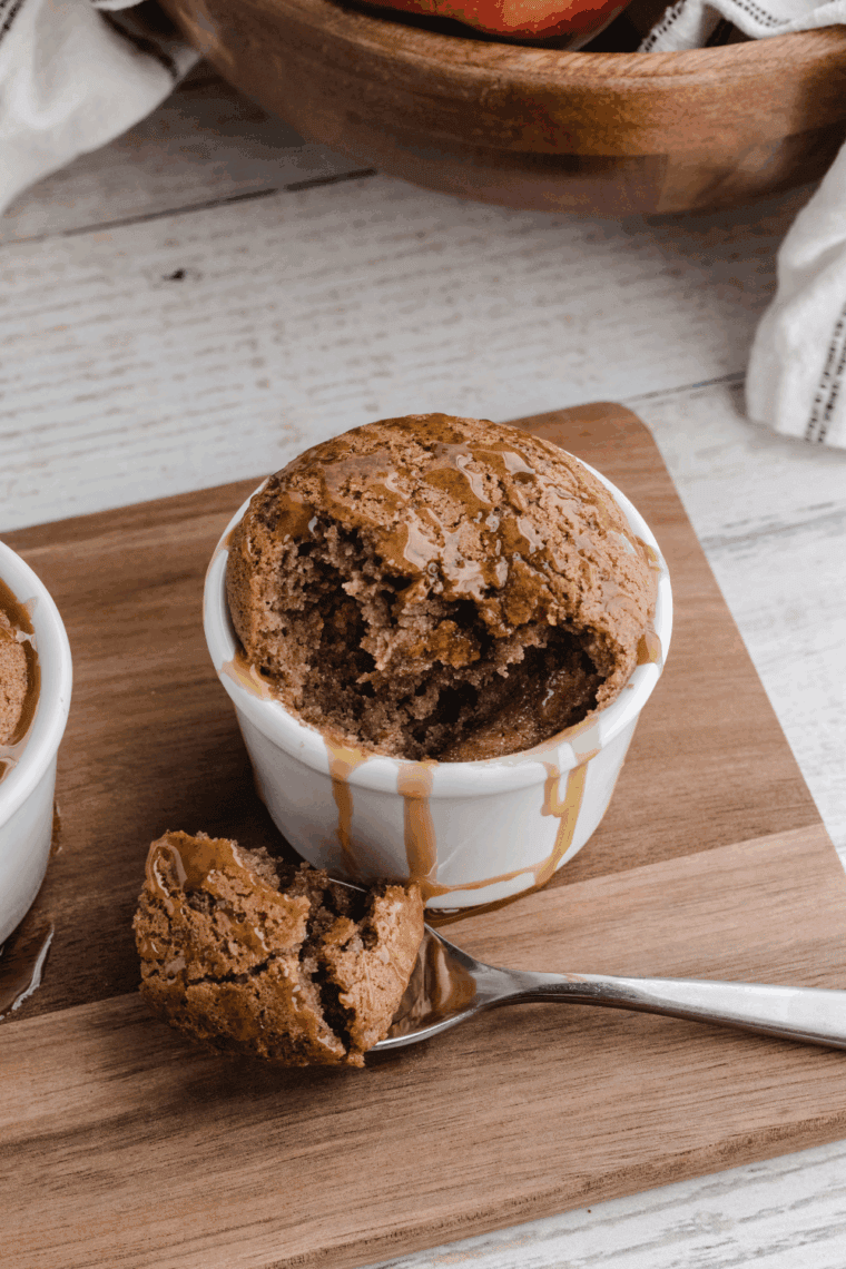 Easy air fryer salted caramel apple mug cake topped with caramel sauce