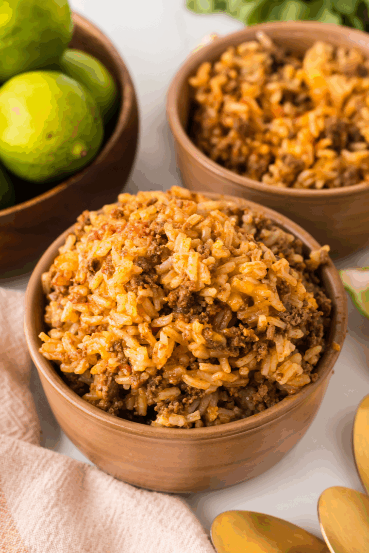 Fluffing the cooked Bojangles copycat dirty rice with a fork to distribute the meat and spices evenly.