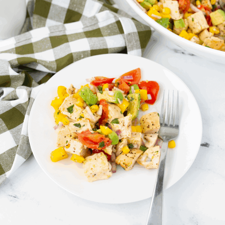 Creamy homemade mango salad dressing in a small bowl with fresh mango pieces
