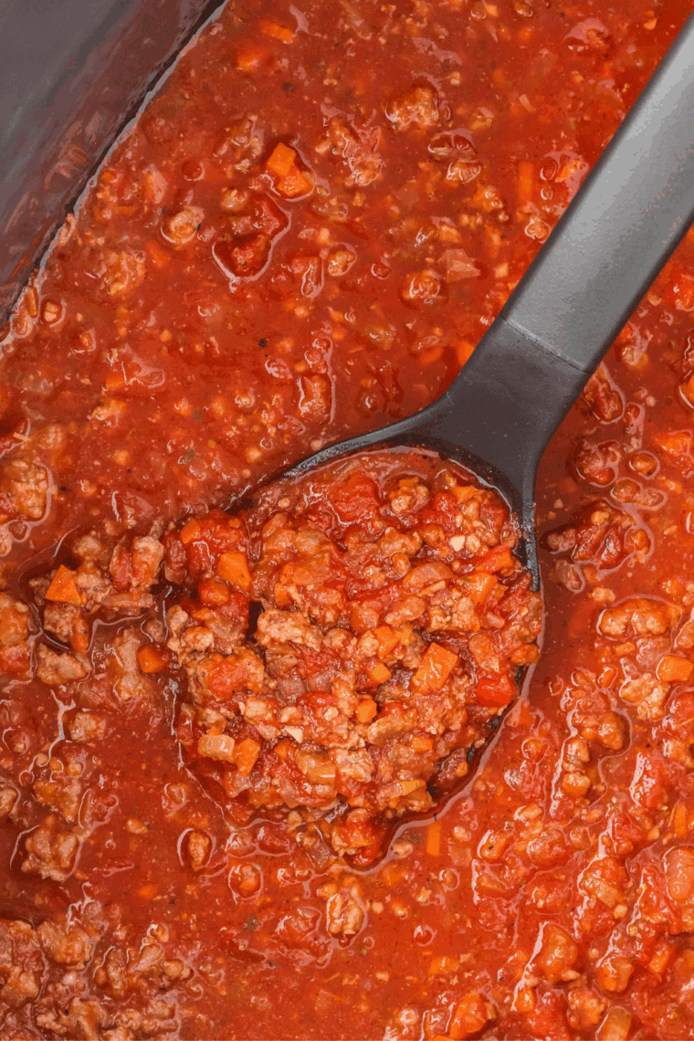 Easy Olive Garden bolognese sauce served over pasta with rich meat sauce and parmesan cheese