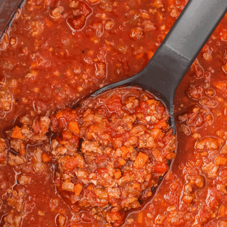 Adjusting thickness of bolognese sauce with broth before serving