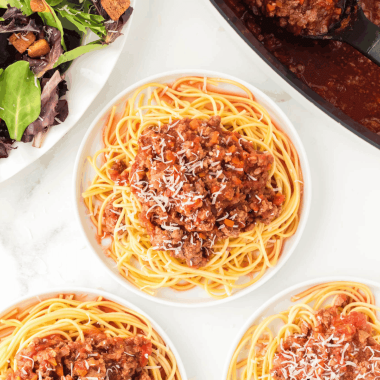 Hearty Olive Garden-style Bolognese Sauce in a crockpot with ground beef, Italian sausage, tomatoes, and herbs ready to serve over pasta.
