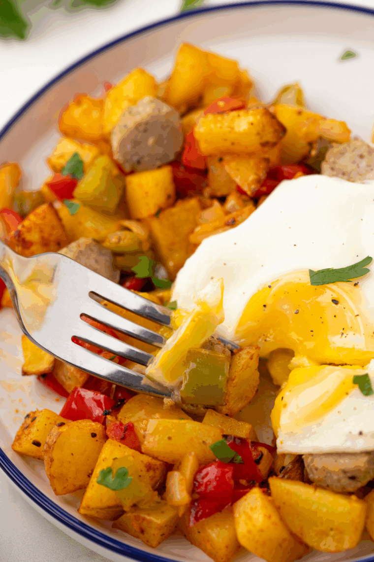 First Watch Copycat Market Hash with golden potatoes, sautéed chicken, bell peppers, onions, mushrooms, and fresh spinach in a skillet, ready to serve.