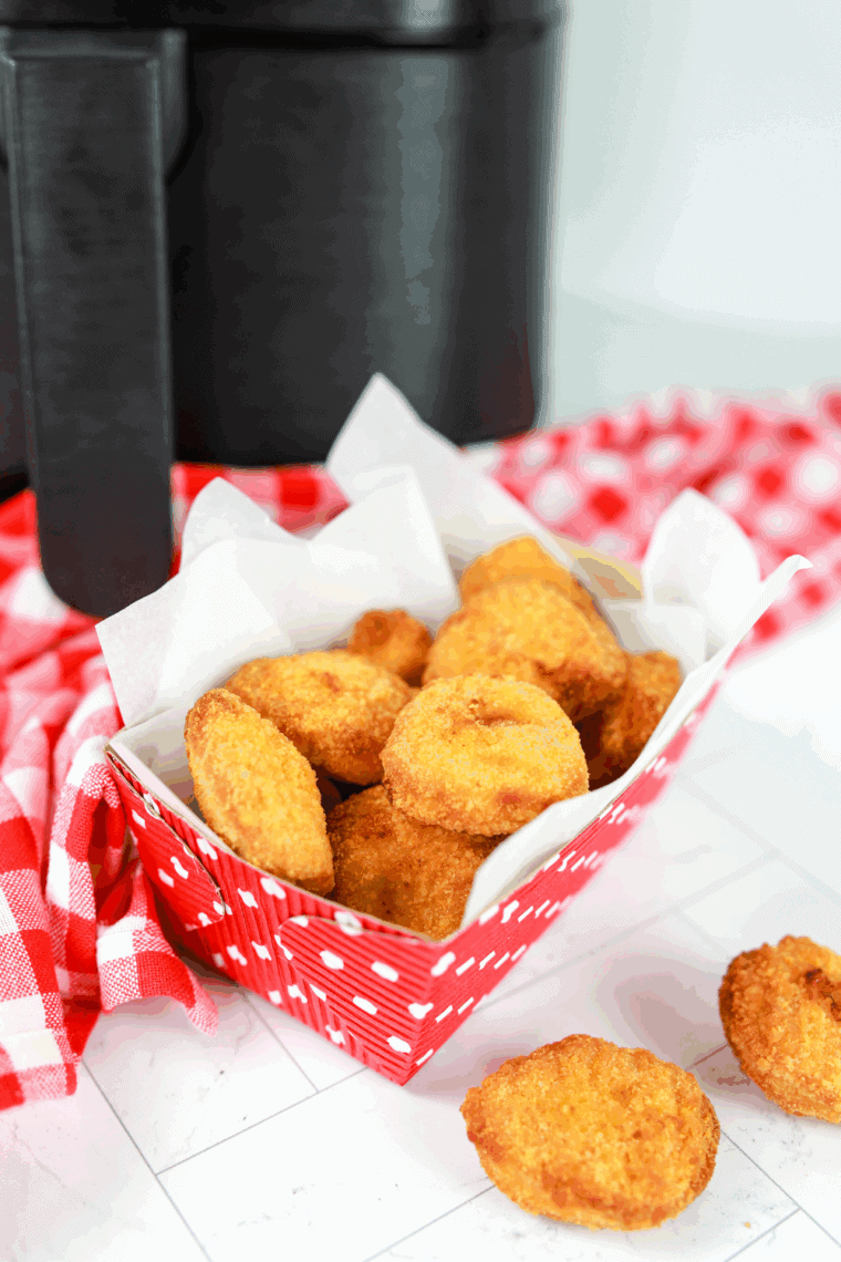 Golden crispy Tyson chicken nuggets cooked in the air fryer, served on a plate with dipping sauce.