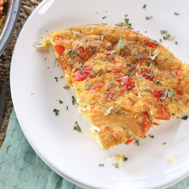 Air fryer egg white and roasted red pepper egg bites on a plate, garnished with fresh chopped chives
