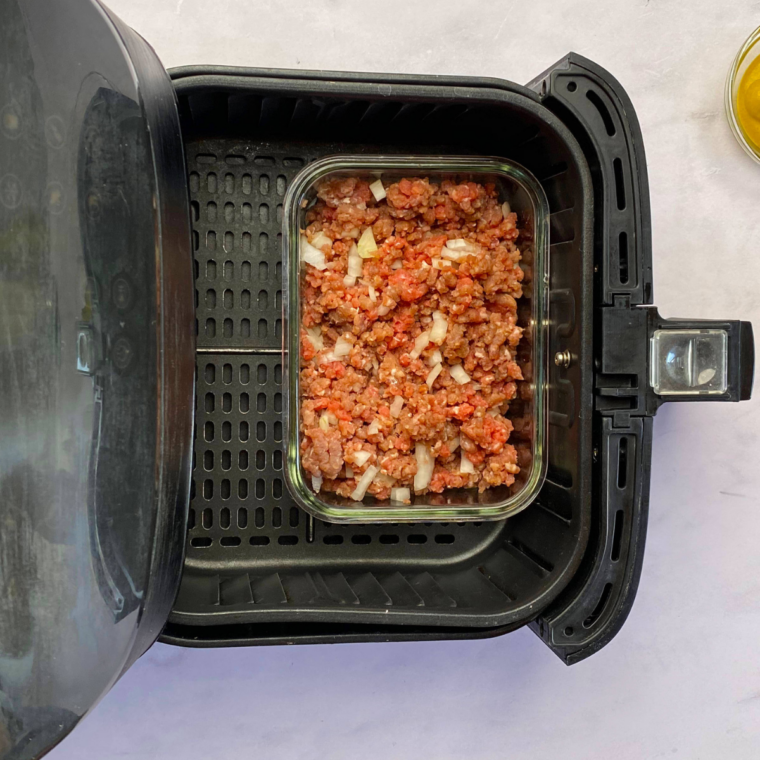 Ground beef mixture cooking in the air fryer at 375°F (190°C), being stirred halfway through the 8–10 minute cook time.