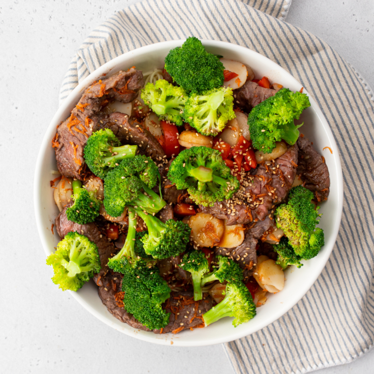 Easy air fryer beef lo mein with tender steak, mixed vegetables, and savory noodles garnished with sesame seeds and green onions