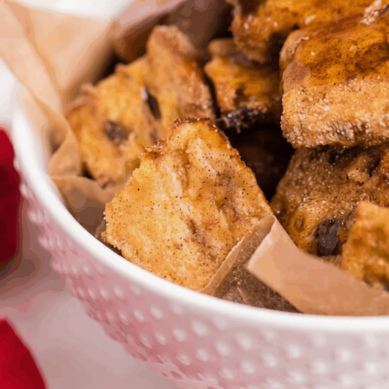 Air fryer French toast bites golden brown on a plate with syrup