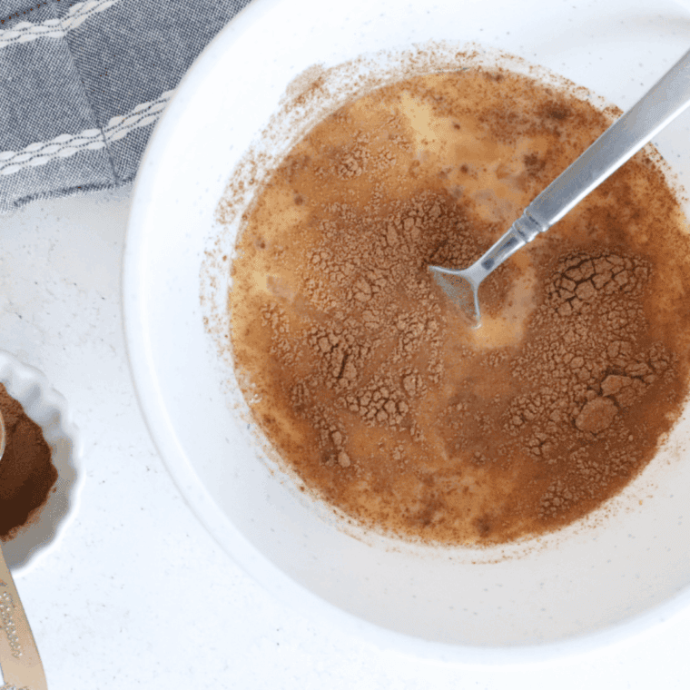 Whisking eggs, milk, vanilla, cinnamon, and sugar in a bowl