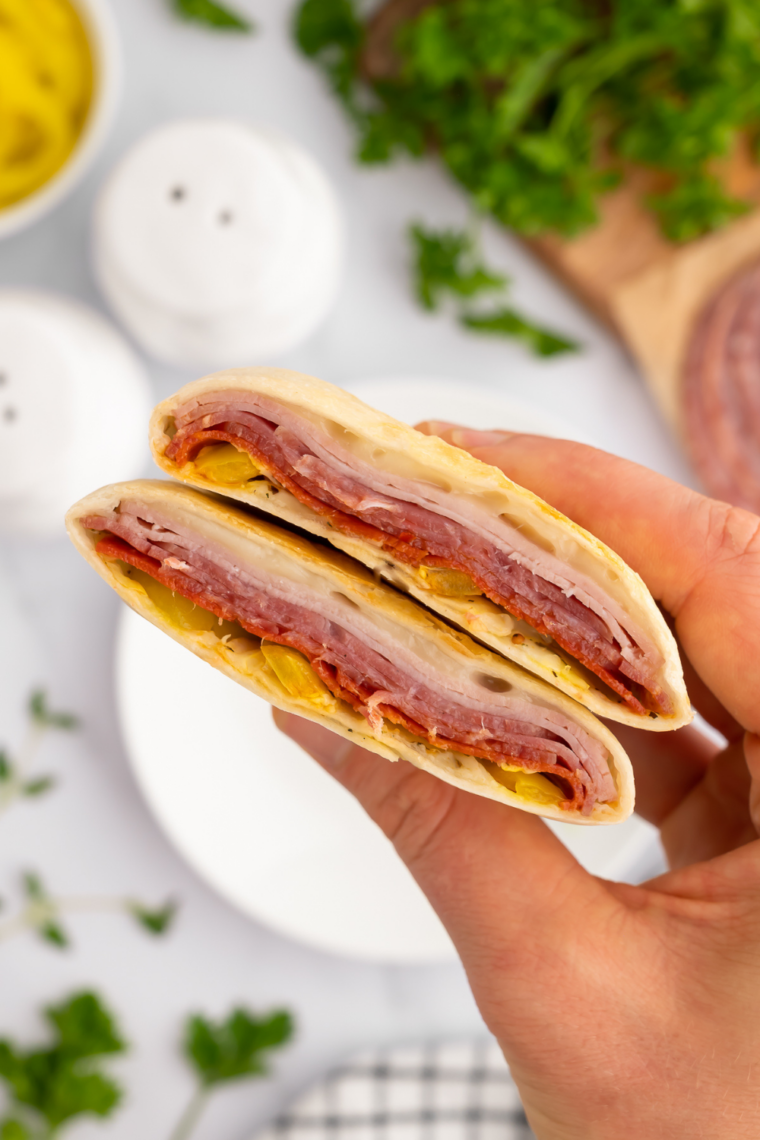 Golden-brown Easy Air Fryer Hot Italian Wraps on a plate, oozing melted cheese and filled with Italian meats.