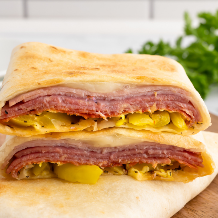 Golden-brown Easy Air Fryer Hot Italian Wraps on a plate, filled with melted cheese, Italian meats, and seasoned veggies.