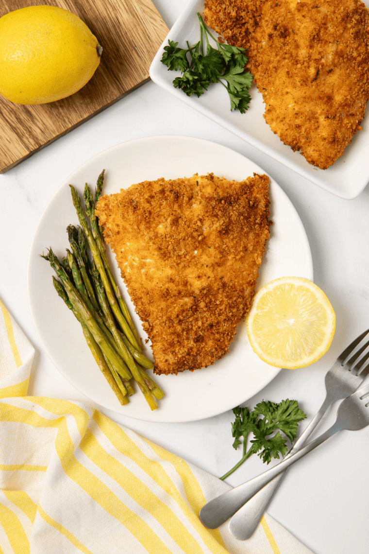 Golden panko crusted red snapper fillet cooked in air fryer with crispy coating and lemon slices