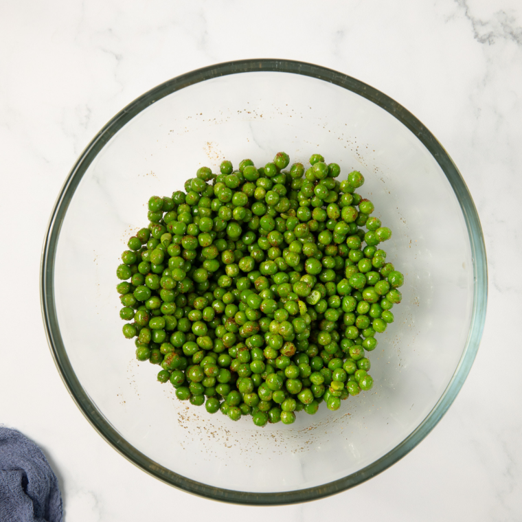 Plain dried peas tossed with olive oil, wasabi powder, salt, and garlic powder in a bowl