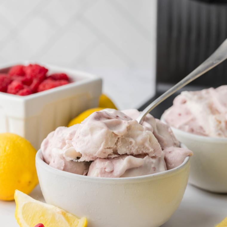 Creamy lemon raspberry gelato served in a bowl, garnished with fresh raspberries and lemon zest, made using the Ninja Creami