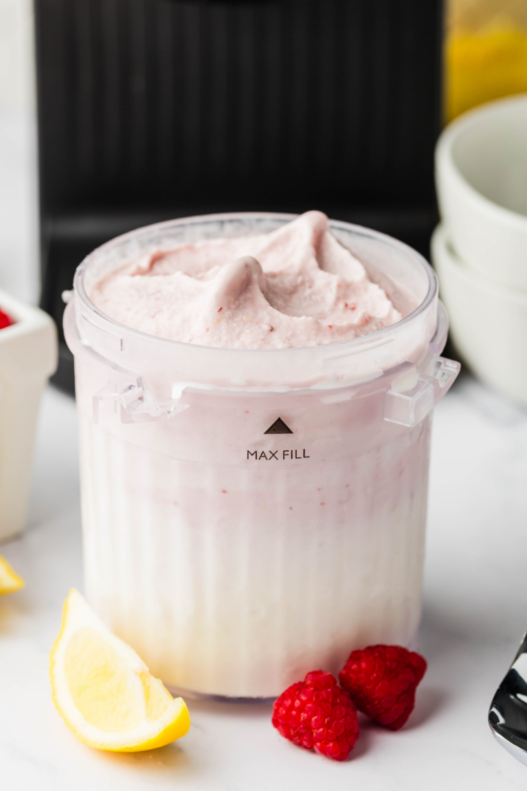 Creamy lemon raspberry gelato served in a bowl, garnished with fresh raspberries and lemon zest, made using the Ninja Creami