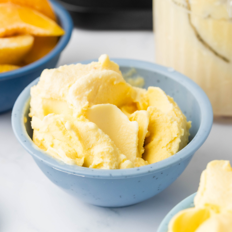 Alt Tag: Scoop of creamy peach gelato made in Ninja Creami, served in a bowl with fresh peach slices