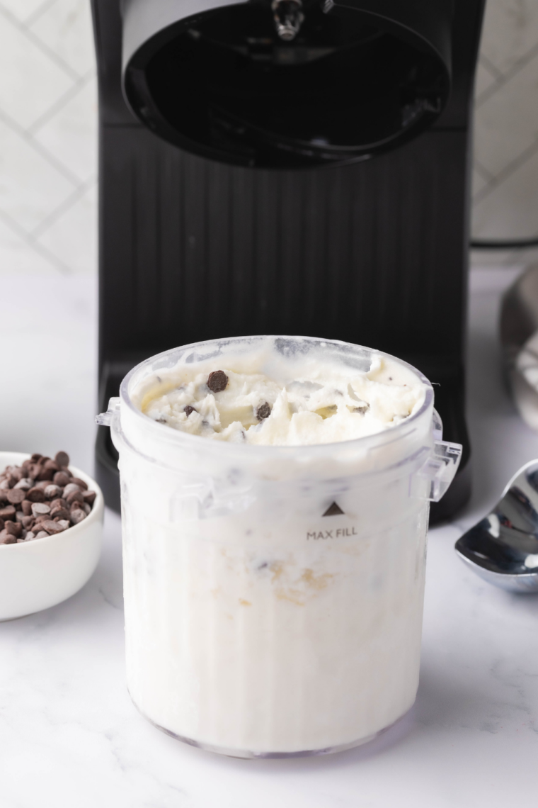 Bowl of creamy stracciatella gelato made in Ninja Creami with chocolate shavings mixed throughout.