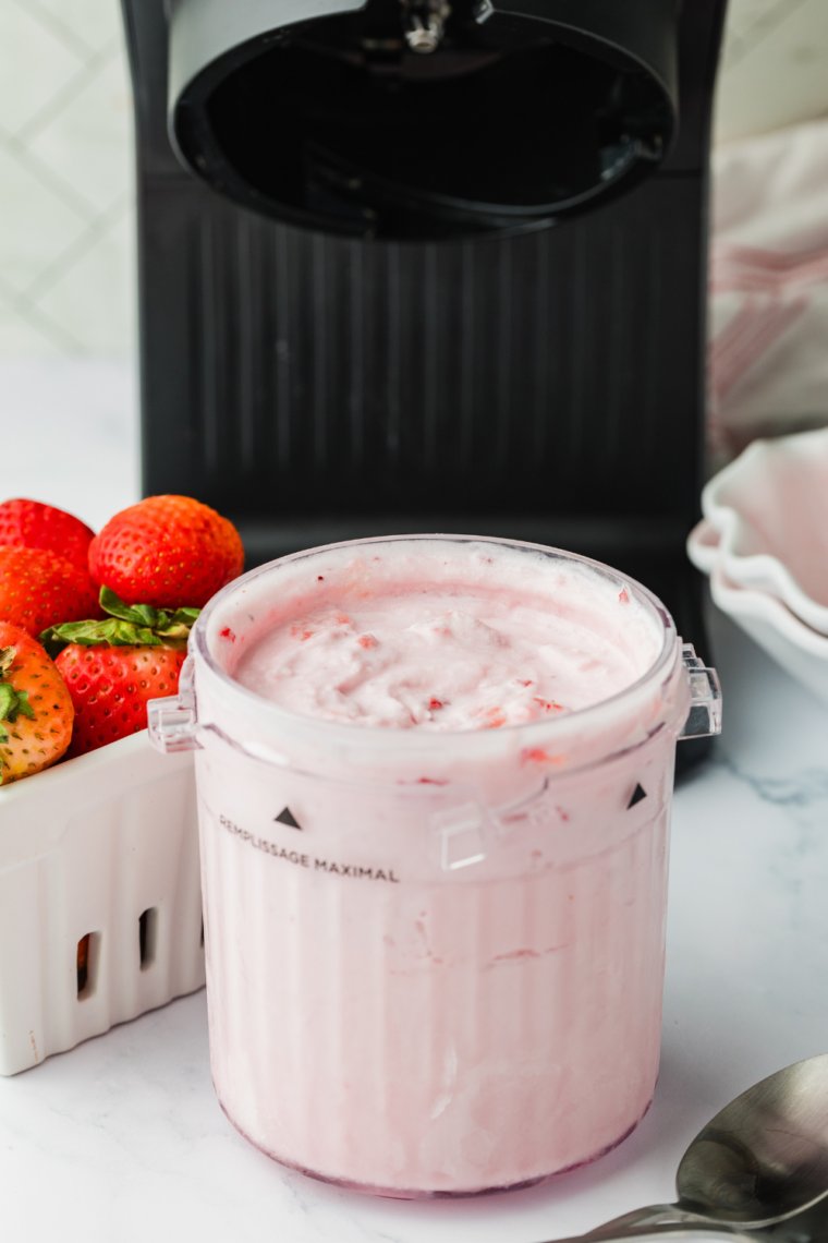 Homemade strawberry gelato scooped into a bowl, made in the Ninja Creami and topped with fresh strawberries.